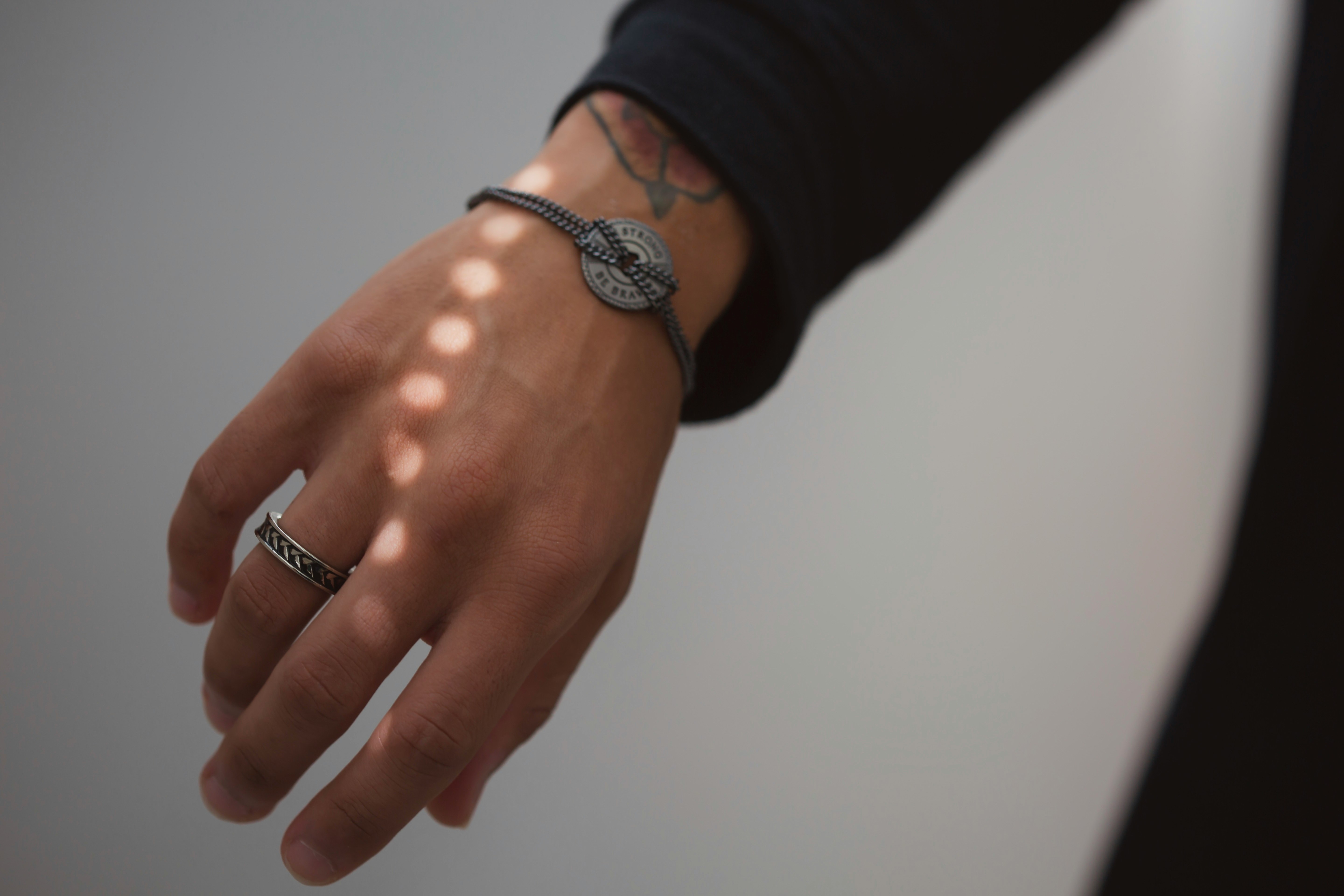 person wearing silver ring and silver bracelet